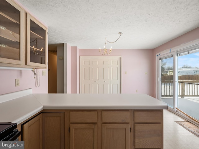 kitchen featuring pendant lighting, a chandelier, black range with electric cooktop, and a textured ceiling