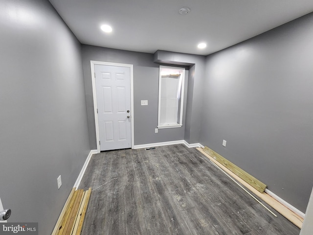 empty room with dark hardwood / wood-style flooring