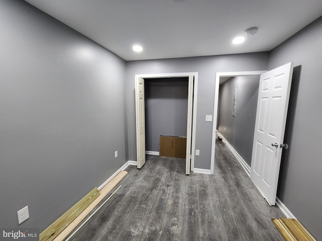 unfurnished bedroom featuring a closet and dark wood-type flooring