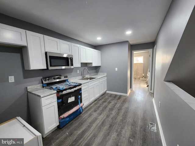 kitchen featuring dark hardwood / wood-style floors, black electric range oven, white cabinetry, and sink