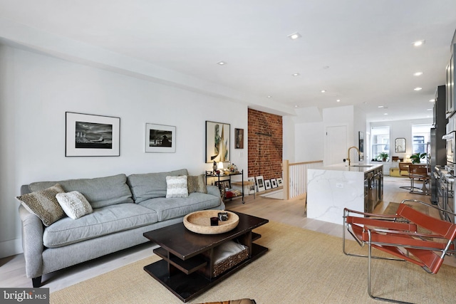 living room featuring light wood-type flooring and sink