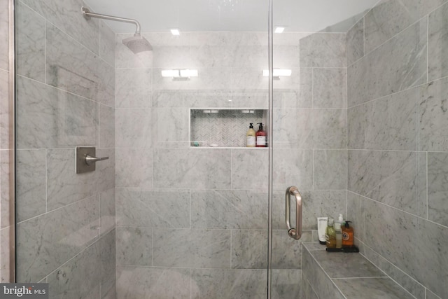 bathroom with a shower with door