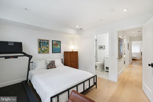 bedroom with light wood-type flooring and ensuite bath