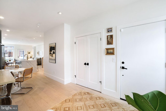 hall featuring light hardwood / wood-style floors and sink