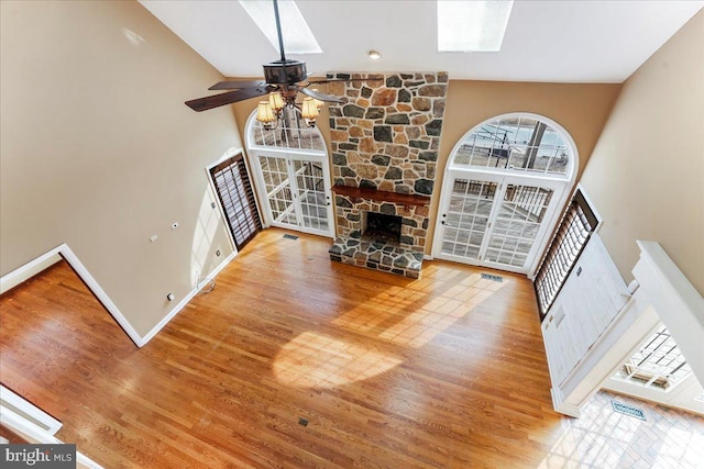 unfurnished living room featuring ceiling fan, a fireplace, high vaulted ceiling, and wood-type flooring