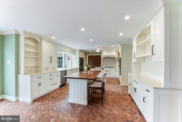 kitchen with a kitchen island, dishwasher, white cabinets, decorative backsplash, and ceiling fan