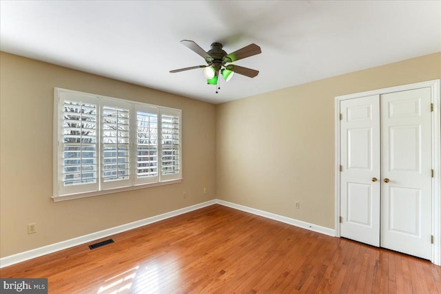 unfurnished bedroom featuring light hardwood / wood-style flooring, a closet, and ceiling fan