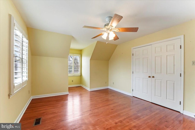 additional living space with ceiling fan, wood-type flooring, and vaulted ceiling