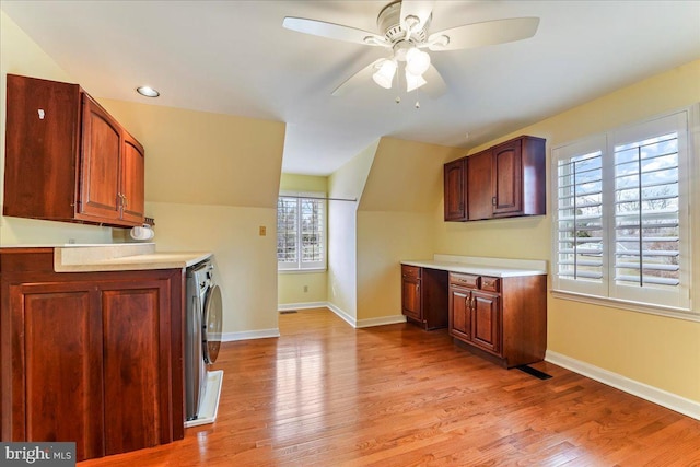 kitchen with ceiling fan, lofted ceiling, washer / clothes dryer, and light hardwood / wood-style floors