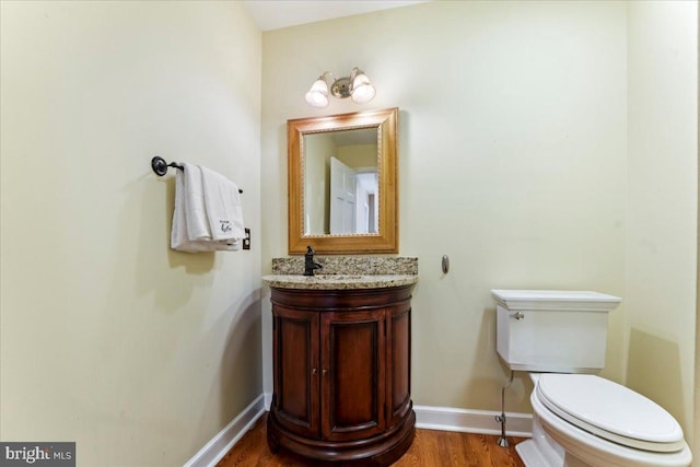 bathroom with vanity, wood-type flooring, and toilet