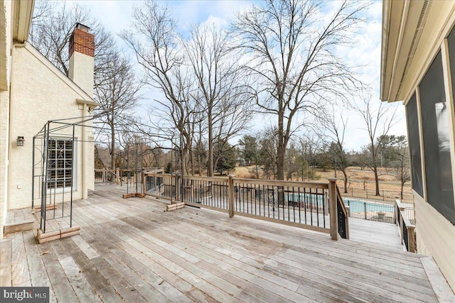 wooden deck featuring a fenced in pool