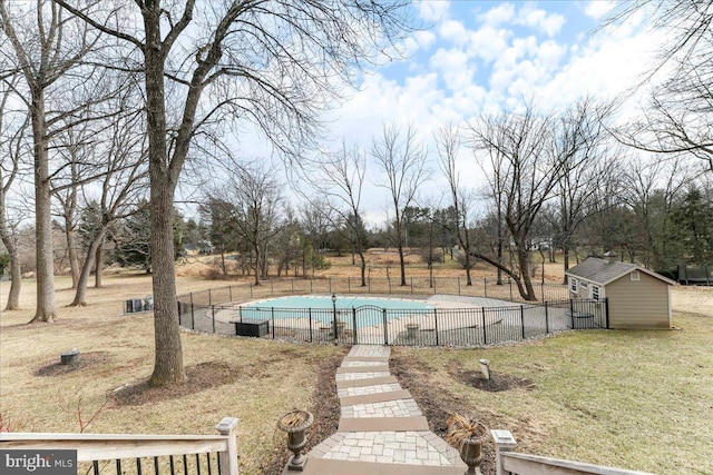 view of pool with a shed and a lawn