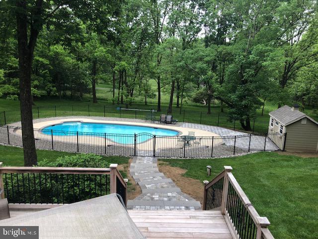 view of swimming pool featuring a yard and a shed