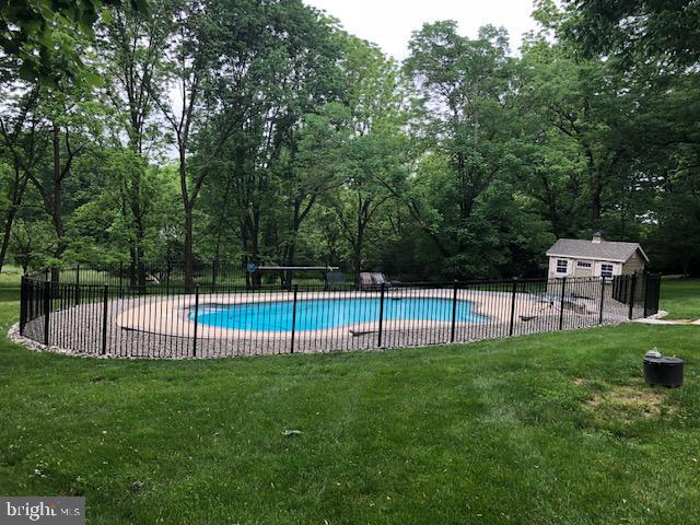 view of swimming pool featuring an outdoor structure and a lawn