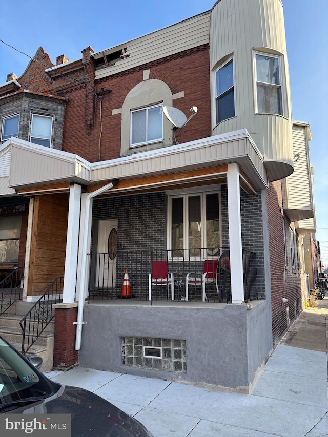 townhome / multi-family property featuring covered porch