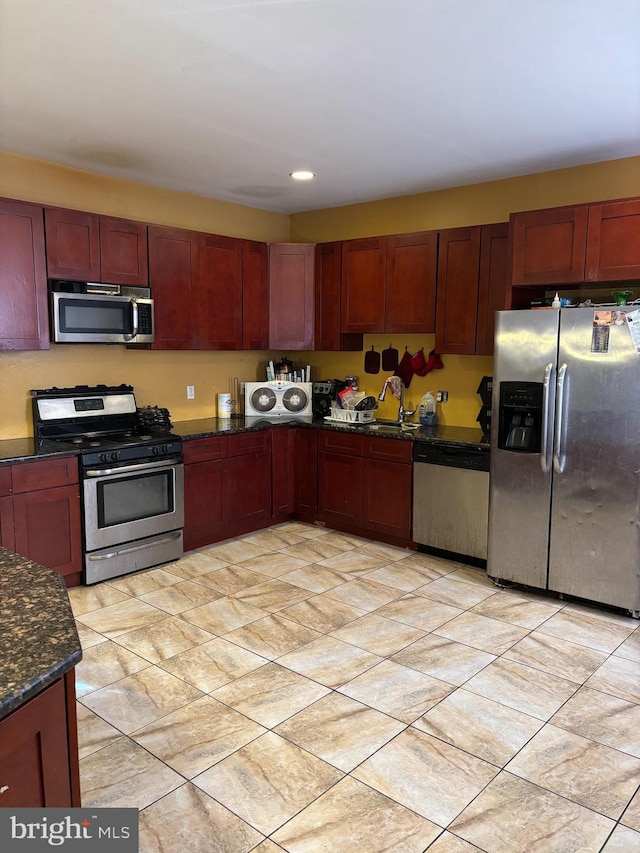 kitchen with stainless steel appliances and dark stone countertops