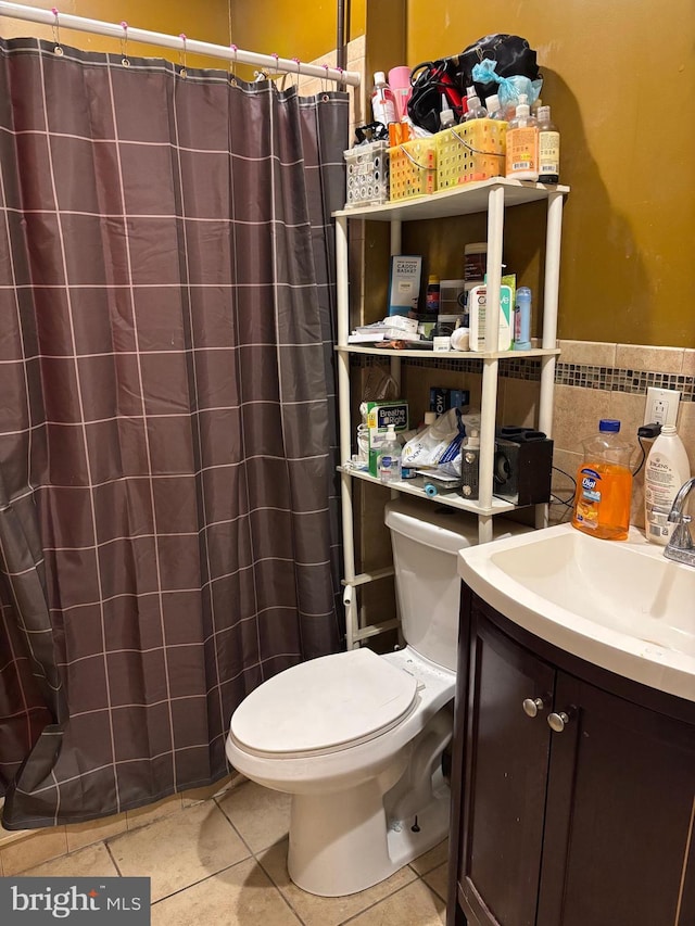 bathroom featuring tile patterned floors, curtained shower, vanity, and toilet