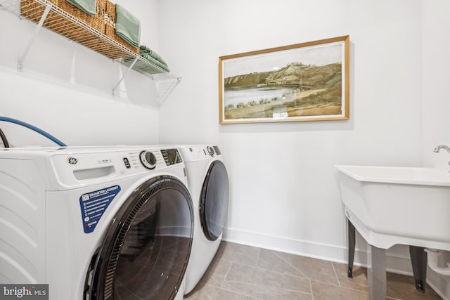 clothes washing area with separate washer and dryer and light tile patterned floors