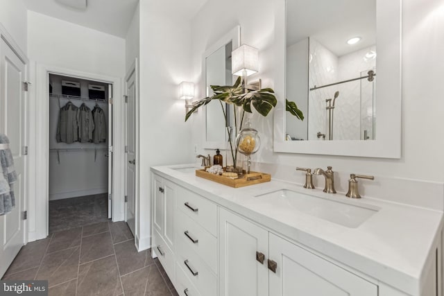 bathroom with tile patterned flooring, vanity, and walk in shower