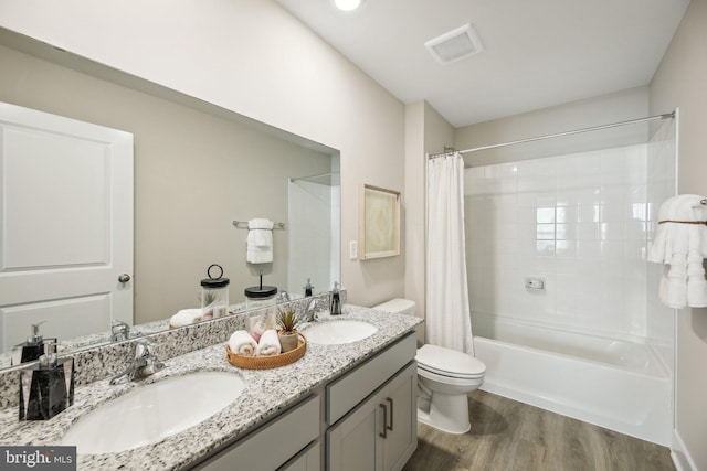 full bathroom with wood-type flooring, vanity, toilet, and shower / bath combo with shower curtain