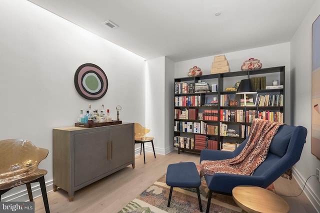 living area with light hardwood / wood-style floors and bar