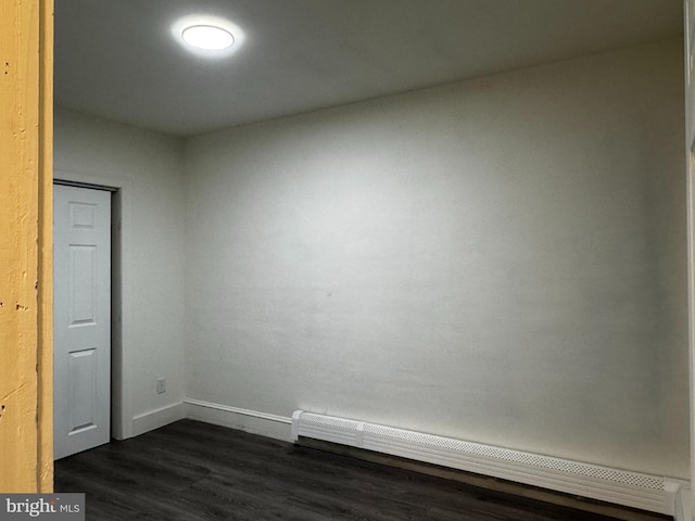 spare room featuring dark hardwood / wood-style floors and a baseboard radiator