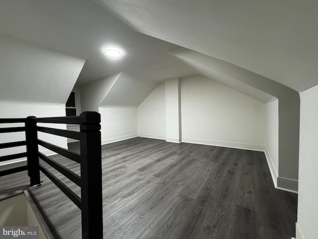 additional living space with dark hardwood / wood-style floors and vaulted ceiling