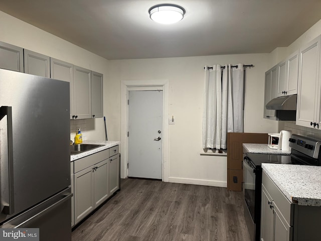 kitchen featuring backsplash, dark hardwood / wood-style floors, gray cabinets, and stainless steel appliances