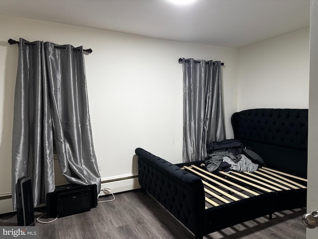 bedroom featuring a baseboard radiator and dark hardwood / wood-style floors