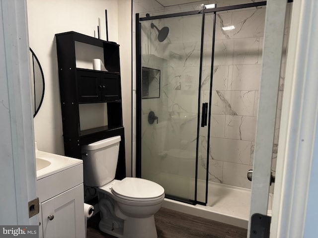 bathroom featuring vanity, hardwood / wood-style flooring, toilet, and walk in shower