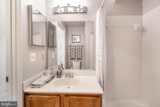 full bathroom featuring vanity, shower / bath combo, and toilet