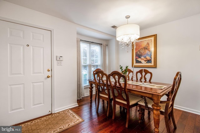 dining area with a chandelier and dark wood-type flooring