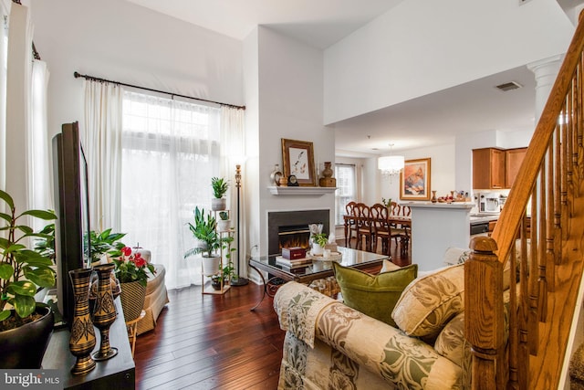 living room with dark wood-type flooring and a high ceiling