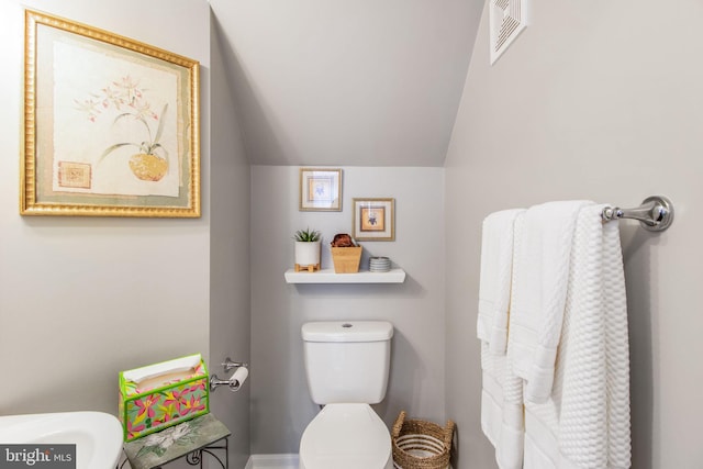 bathroom featuring vaulted ceiling and toilet