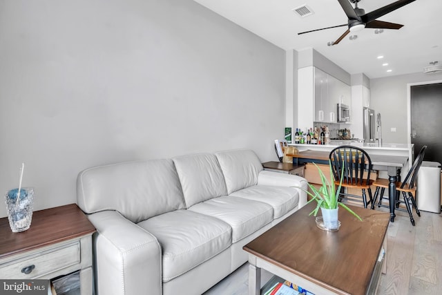 living room featuring light hardwood / wood-style floors and ceiling fan