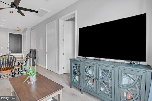 living room featuring ceiling fan and light wood-type flooring