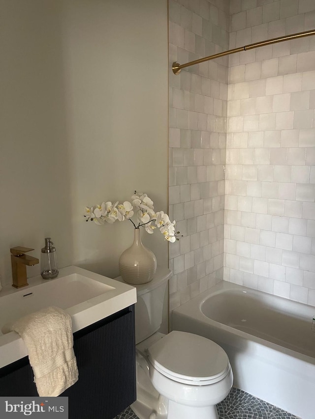 full bathroom featuring tile patterned floors, tiled shower / bath, vanity, and toilet