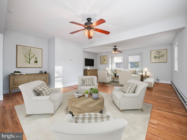 living room with wood-type flooring, ceiling fan, and a baseboard heating unit