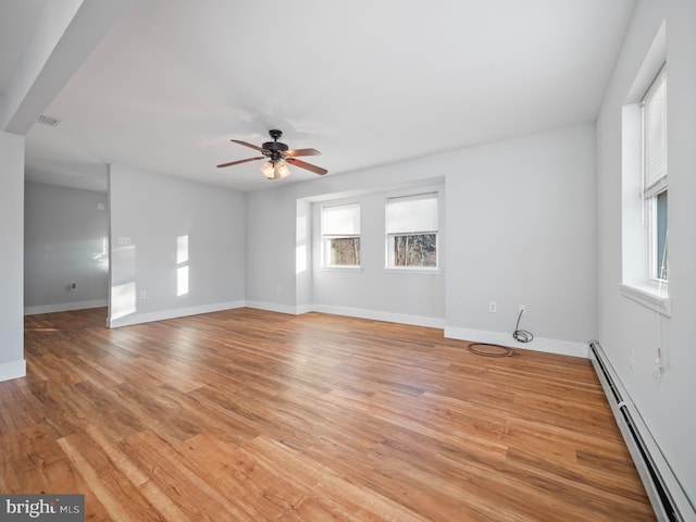 unfurnished room featuring baseboard heating, ceiling fan, and light hardwood / wood-style floors