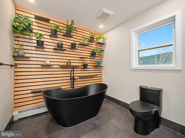 room details with toilet, baseboard heating, and a tub