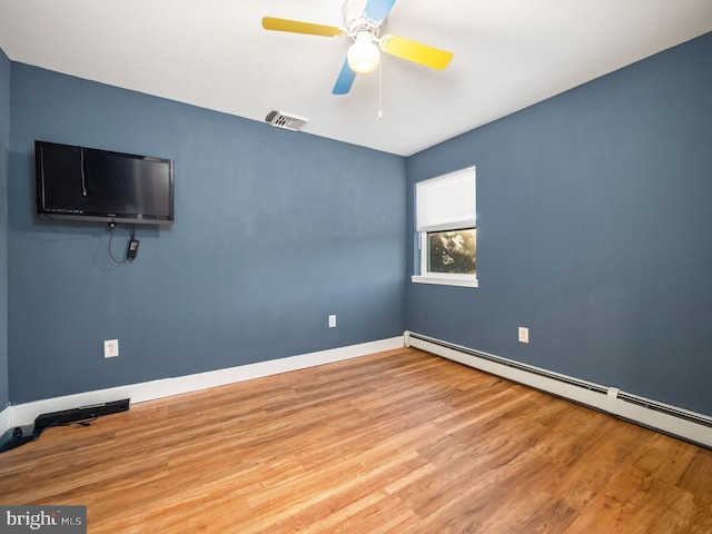 empty room with hardwood / wood-style flooring, baseboard heating, and ceiling fan