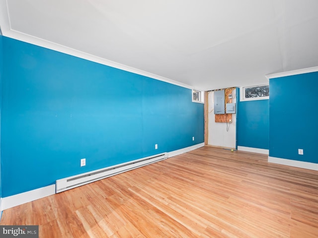 unfurnished living room featuring ornamental molding, hardwood / wood-style flooring, and a baseboard heating unit