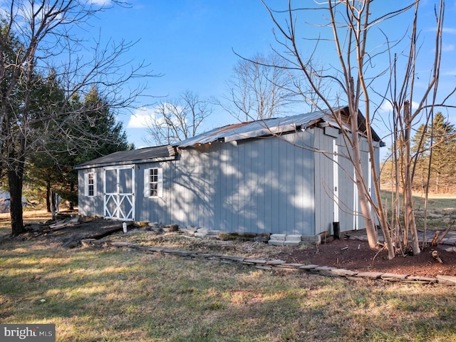 view of property exterior with an outbuilding and a lawn