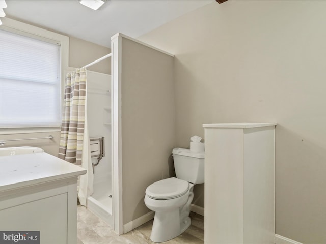 bathroom featuring vanity, curtained shower, and toilet