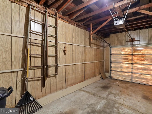 garage featuring wooden walls and a garage door opener