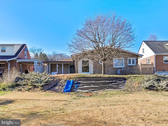 back of property with cooling unit and a lawn