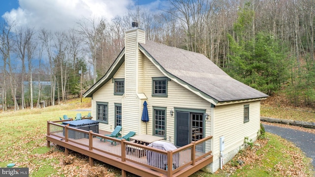 back of house featuring a deck and a jacuzzi