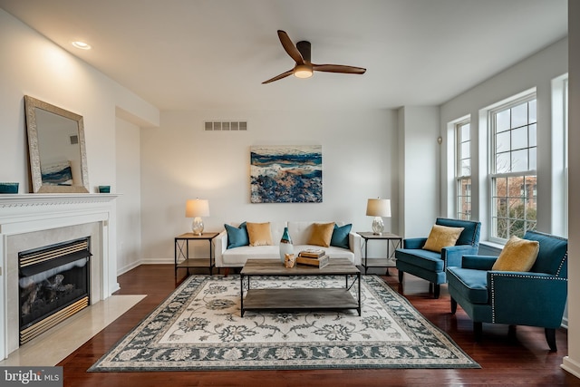 living room featuring ceiling fan and dark hardwood / wood-style floors