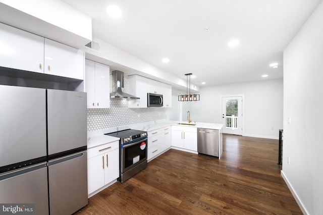 kitchen with wall chimney range hood, hanging light fixtures, white cabinetry, kitchen peninsula, and stainless steel appliances