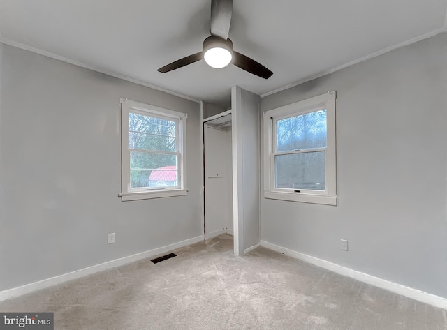 unfurnished bedroom with multiple windows, ceiling fan, a closet, and light carpet